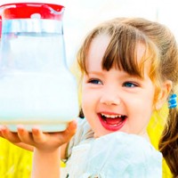 Девочка держит в руках кувшин с молоком